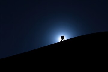 Silhouette of a person with backpack climbing a dark hill towards the bright light of the sun or moon.