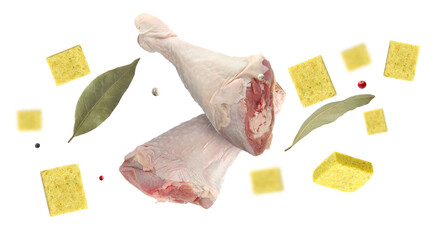 Bouillon cubes, chicken drumsticks, dry bay leaves and peppercorns flying in air on white background