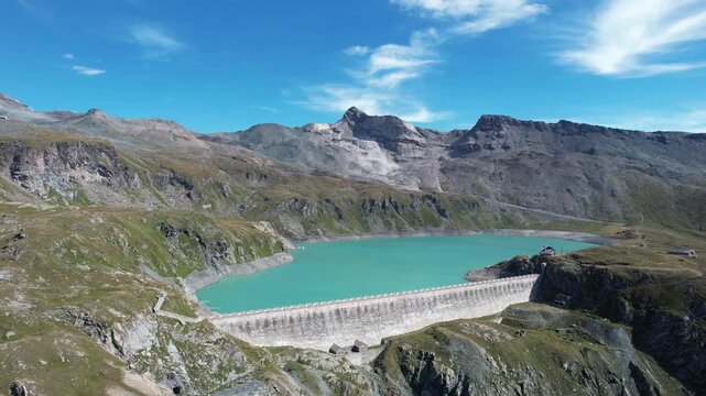 Aerial view of the Diga del Goillet dam with turquoise water contrasting against the rugged mountain terrain, Diga del Goillet, Valle d'Aosta, Italy.