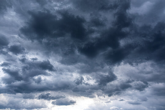 Dense dark storm clouds fill the overcast sky with a soft light glowing from below.