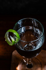 Cocktail glass with lime peel garnish on the rim of the glass
