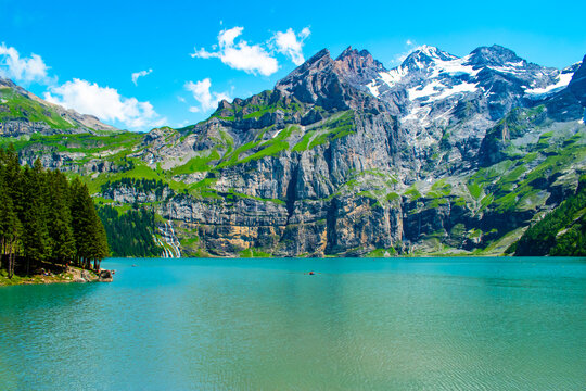 Oeschinen Lake, Switzerland, is a crystal-clear alpine lake surrounded by towering mountains and lush meadows. Ideal for hiking, it offers stunning natural beauty and outdoor adventures. - Powered by Adobe