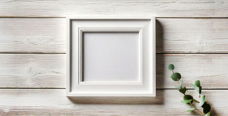 White photo frame on white wooden background. Empty space for text