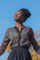 Black woman enjoying sunshine outdoors with eyes closed. Mindfulness and mental wellness concept.