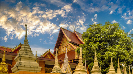 Side view of Wat Ong Teu Mahawihan (Temple of the Heavy Buddha) with stupas in the foreground, Vientiane, Laos.
