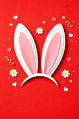 Cute bunny ears headband on red festive background with hearts and confetti