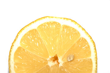 Close up of a cut lemon slice with a pip o a white background