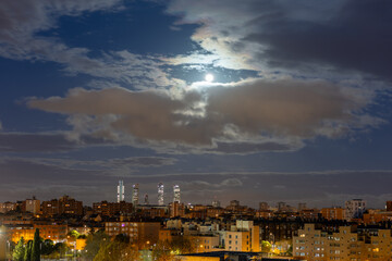 Obraz premium The moon over the four towers in the city of Madrid, Spain