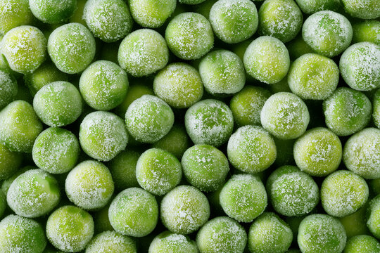 Frozen green peas covered with white rime in close up pile