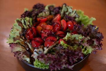 Salad served in a bowl, on the table