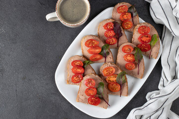 Homemade sandwiches with turkey pate and cherry tomatoes, also a cup of coffee, Top view