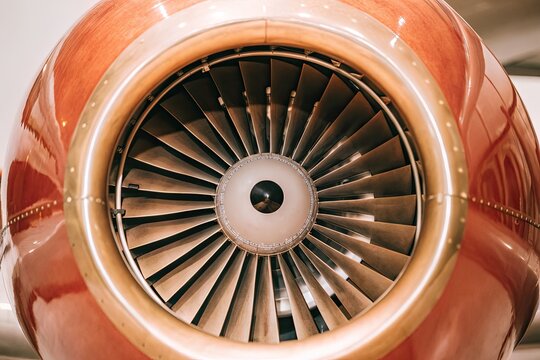 Close-up of a powerful jet engine with its intricate blades on a warm-toned aircraft - Powered by Adobe