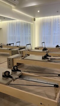 Modern pilates studio interior with several wooden reformers