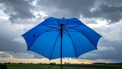 Blue Umbrella Against Cloudy Overcast Sky Symbolizing Shelter, Contrast, and Preparedness in Stormy Weather