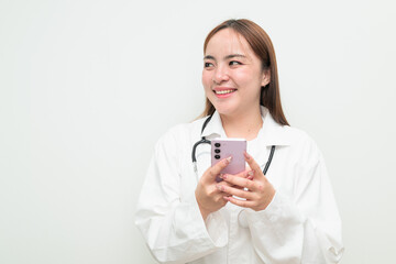 Portrait of young happy Asian female doctor against white background using phone thinking
