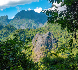 Tropical vegetation and towering karst mountains along the hiking trails of Vang Vieng, Vientiane Province, Laos
