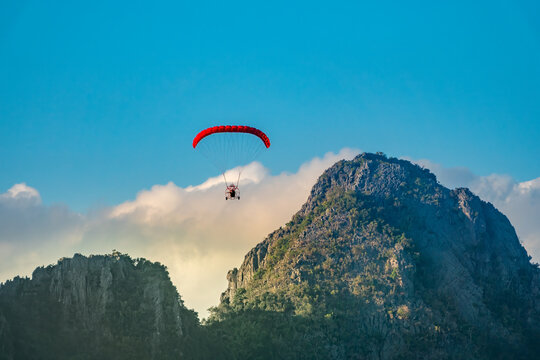 Closeup of a microlight aircraft gliding above the stunning karst rock formations in the Nam Song river valley in the resort city of Vang Vieng, Vientiane Province, Laos