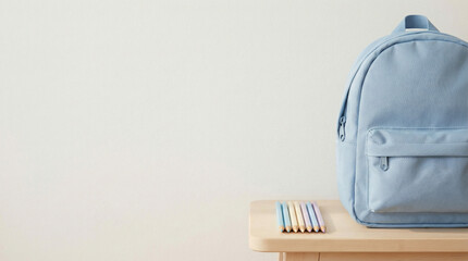 Light blue school bag next to pencils on wooden table, representing National Girl Child Day  
