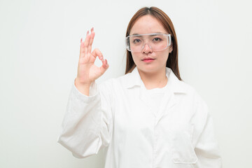 Portrait of Asian female research scientist against white background making OK sign hand gesture