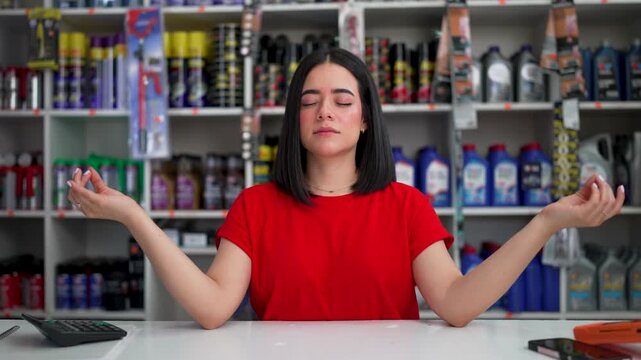 Calm woman practicing yoga and meditation to manage stress at her retail job in a hardware store