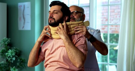 Indian physiotherapist treating young patient for neck and shoulder pain during physical therapy session as experienced male therapist provides manual treatment inside modern Indian clinic
