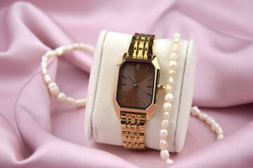 Closeup minimal fashion wristwatch for women on pink background.