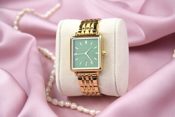 Closeup minimal fashion wristwatch for women on pink background.