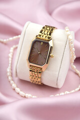 Closeup minimal fashion wristwatch for women on pink background.