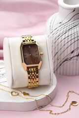 Closeup minimal fashion wristwatch for women on pink background.