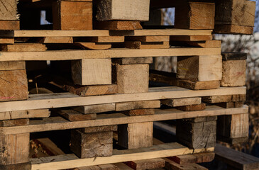 Stacked wooden pallets in warm evening sunlight.