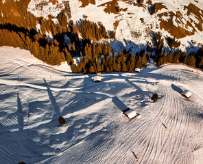 Ski slope along wooden huts - top down aerial view