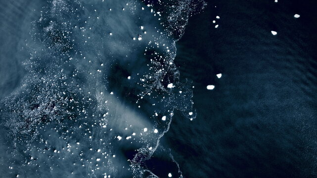 Aerial view of icy waterscapes where glaciers meet the sea, dotted with floating ice, creating a mesmerizing dance of light and shadow, Blackstone Bay, Alaska, United States.