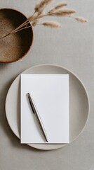 Blank notepad and pen on a simple plate with a decorative bowl nearby in a cozy setting