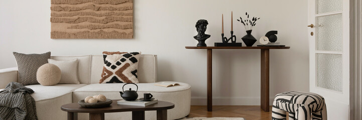 Modern living room with sculptural black accents, soft textiles, and abstract wall art in warm,...