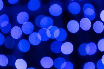 Elegant blue bokeh lights shimmer gently in the dark, forming a calm festive atmosphere full of seasonal charm.