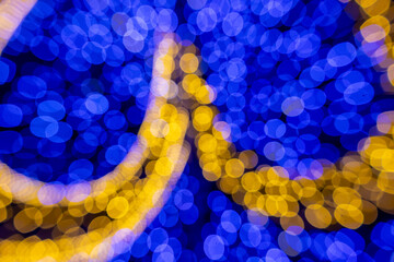 Blue and yellow bokeh lights shimmer softly, adding glow and joy to the Christmas season.