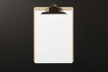 Blank white paper on wooden clipboard on dark background. template mock up