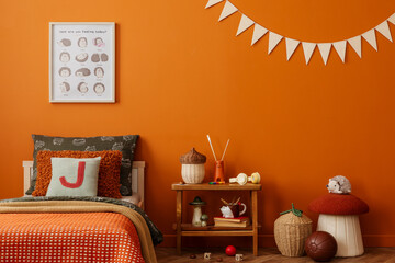 Warm children room with an orange wall, cozy bedding and playful woodland-themed decor styled in...