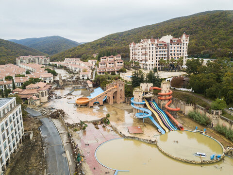 Aerial view of a aquapark and surrounding buildings submerged in muddy floodwater, a scene of devastation etched against the backdrop of rolling hills, Elenite, Burgas, Bulgaria.