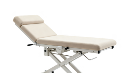 Isolated adjustable medical treatment table with cushioned surface designed for patient positioning during vestibular assessments set against a clean white background.