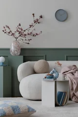 Fototapete Musik Creative composition of spring living room interior with boucle sofa, stylish coffee table, green stand, glass vase with flowering branches and personal accessories. Home decor. Template.  © FollowTheFlow