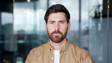 Portrait of serious handsome businessman standing at the workplace in a business office. Headshot of confident focused successful bearded manager or entrepreneur posing looking at camera. Close up - Powered by Adobe