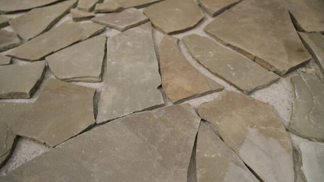 Natural irregular flagstone pieces laying on the ground, ready for construction or landscaping pathway design
