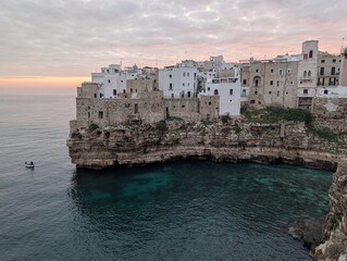 Panorama iconico della spiaggia Lama Monachile di  Polignano a Mare con cielo rosa all'alba