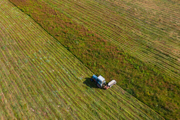 an old tractor mows grass in a meadow