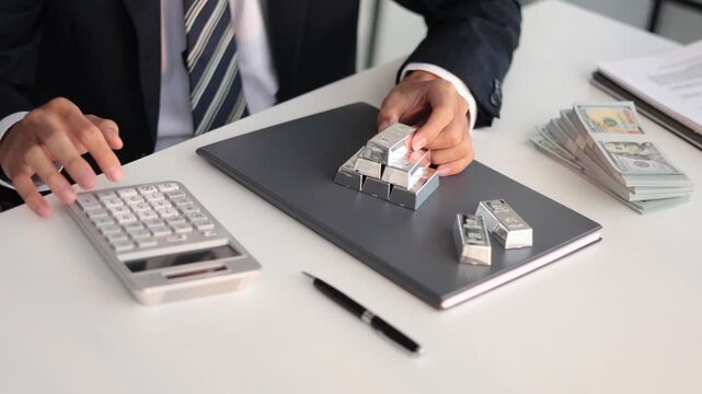 Silver bars on table. Businessman investing in precious metals to protect asset against inflation, currency depreciation.