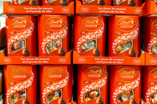 Lindt Lindor Milk chocolate candies in red packaging arranged on supermarket shelf in grocery store retail