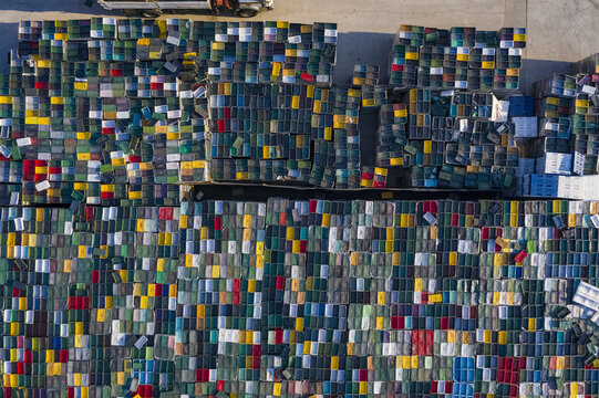 Aerial view of stacked colorful containers in a large storage area, a mosaic of hues under the sun's gaze, Rovinj, Istria County, Croatia.