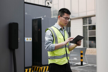 asian Worker uses tablet at charging station