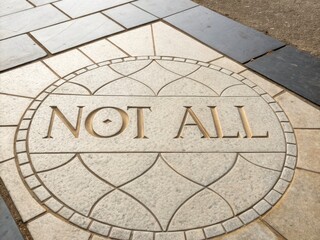 Stone Path With Engraved 'Not All' Text and Geometric Pattern
